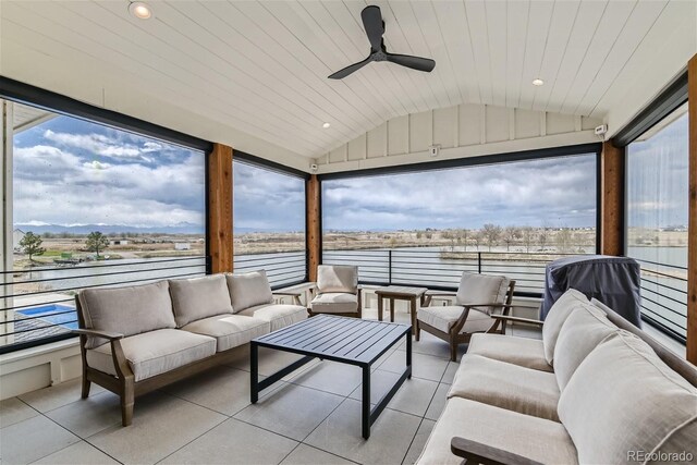 sunroom featuring lofted ceiling, ceiling fan, plenty of natural light, and wood ceiling