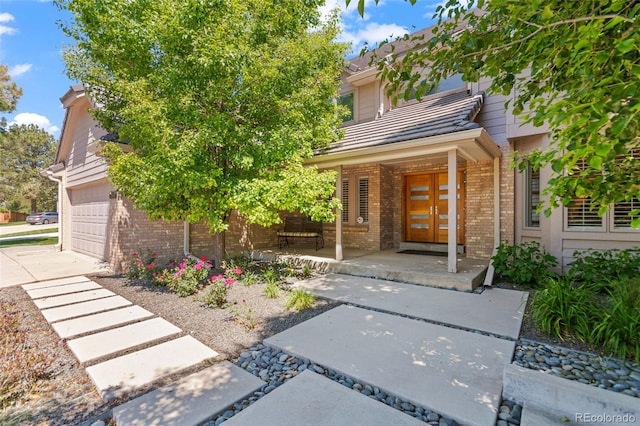 10293 E Sheri Ln, Englewood, CO 80111 - view of front of home with brick siding, covered porch, and a garage