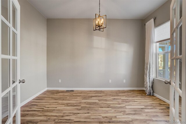 1341 Solitaire St, Colorado Springs, CO 80905 - empty room with french doors, a notable chandelier, baseboards, and light wood-style floors