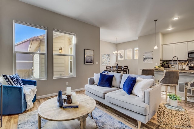 1341 Solitaire St, Colorado Springs, CO 80905 - living area with a notable chandelier, baseboards, light wood-style floors, and recessed lighting