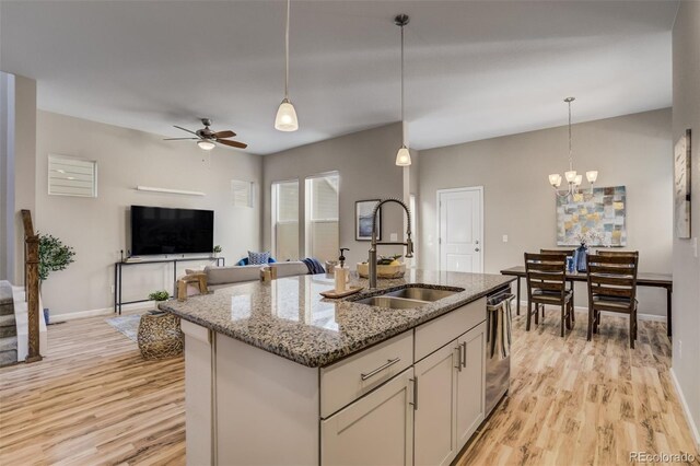 1341 Solitaire St, Colorado Springs, CO 80905 - kitchen featuring a center island with sink, light stone countertops, light wood-style floors, and a sink