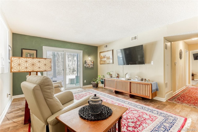 living room with a textured ceiling and light wood-type flooring