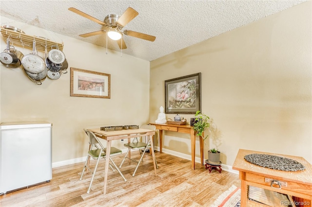 office with ceiling fan, light hardwood / wood-style floors, and a textured ceiling