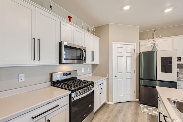 kitchen featuring light hardwood / wood-style floors, white cabinets, stainless steel appliances, and sink