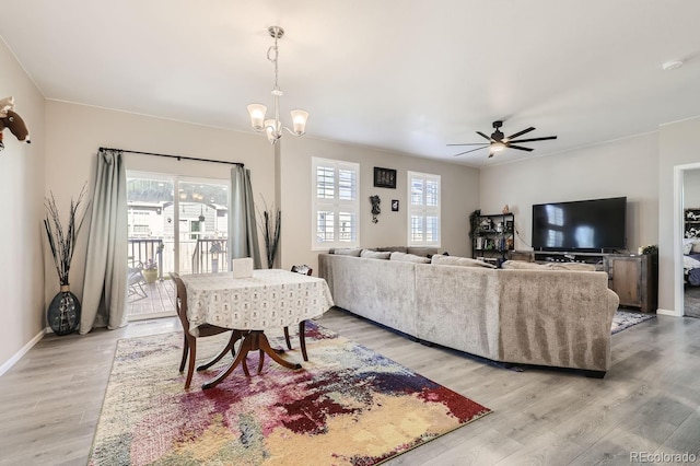 living room featuring light hardwood / wood-style flooring and ceiling fan with notable chandelier