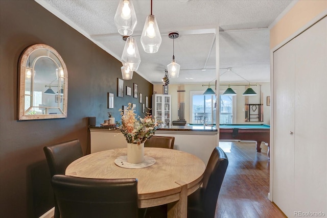 dining room featuring wood finished floors, a textured ceiling, and pool table