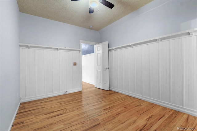 unfurnished room featuring a textured ceiling, light hardwood / wood-style flooring, and ceiling fan