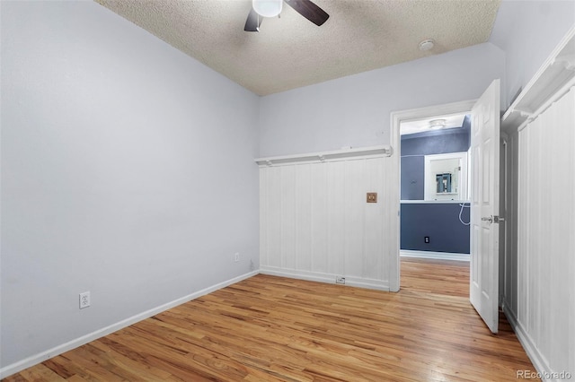 empty room featuring ceiling fan, vaulted ceiling, a textured ceiling, and light hardwood / wood-style flooring