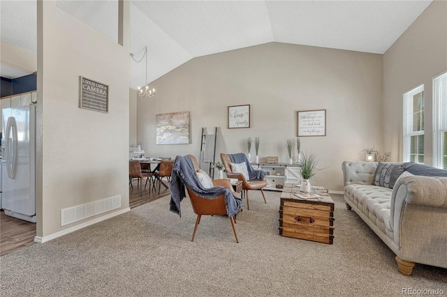 carpeted living room featuring a chandelier, high vaulted ceiling, visible vents, and baseboards