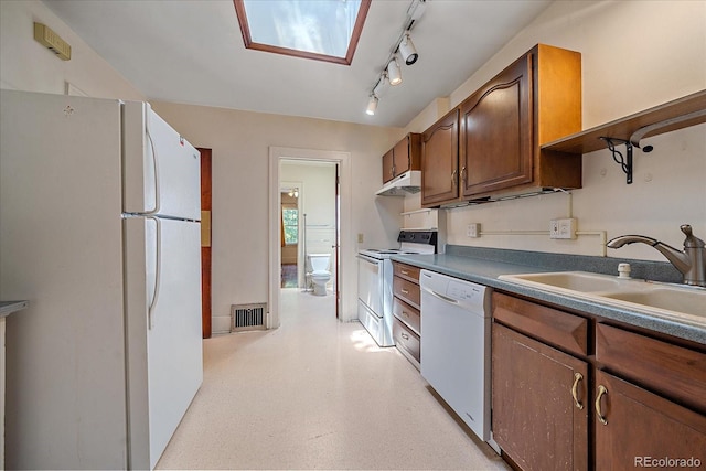 kitchen with white appliances, sink, and a skylight