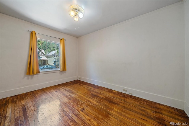 empty room with crown molding and hardwood / wood-style flooring