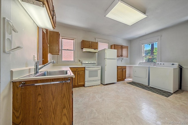 kitchen with washer and dryer, white appliances, and sink