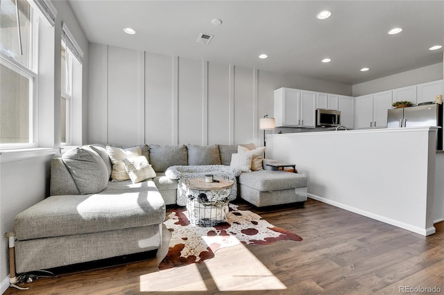 6459 N Dunkirk St, Denver, CO 80249 - living area with wood finished floors, recessed lighting, and a decorative wall