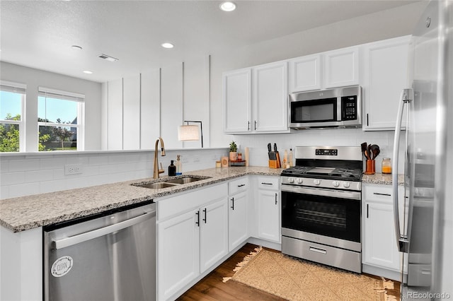 6459 N Dunkirk St, Denver, CO 80249 - kitchen featuring stainless steel appliances, a sink, white cabinets, and recessed lighting