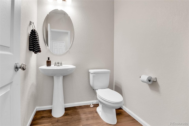 6459 N Dunkirk St, Denver, CO 80249 - bathroom with toilet, wood finished floors, baseboards, and a sink