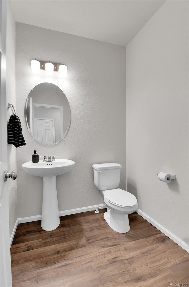 6459 N Dunkirk St, Denver, CO 80249 - half bathroom featuring toilet, wood finished floors, and baseboards