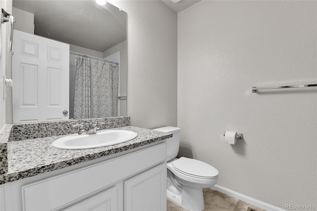 6459 N Dunkirk St, Denver, CO 80249 - full bathroom with toilet, baseboards, vanity, a textured wall, and tile patterned floors