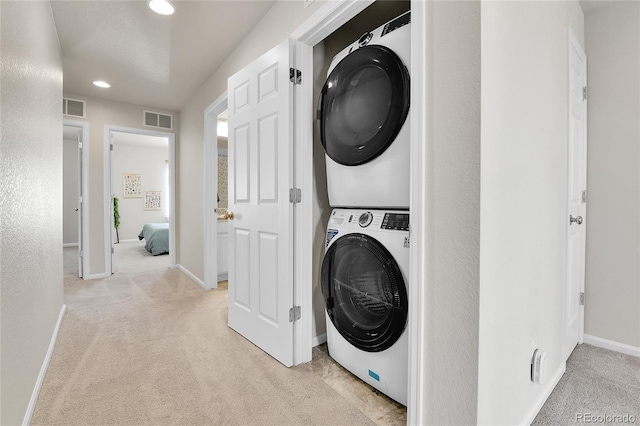 6459 N Dunkirk St, Denver, CO 80249 - washroom with stacked washer and clothes dryer, light colored carpet, recessed lighting, and baseboards