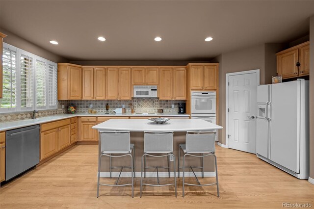 10524 Serengeti Dr, Lone Tree, CO 80124 - kitchen with white appliances, light brown cabinetry, light wood-style flooring, light countertops, and recessed lighting