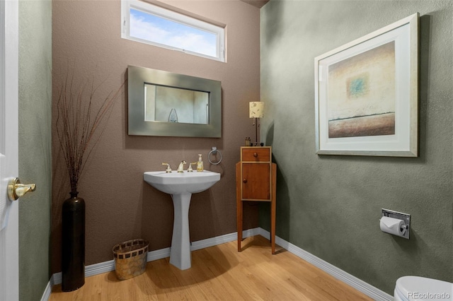 10524 Serengeti Dr, Lone Tree, CO 80124 - half bathroom with wood finished floors, toilet, and baseboards