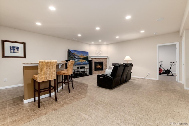 living area with recessed lighting, a brick fireplace, light colored carpet, and baseboards