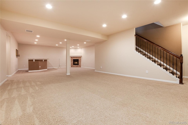 unfurnished living room featuring recessed lighting, light colored carpet, visible vents, baseboards, and stairs