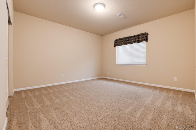 carpeted empty room with visible vents and baseboards