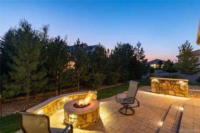 patio terrace at dusk featuring a fire pit