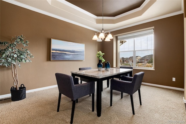 carpeted dining area with a notable chandelier, ornamental molding, a raised ceiling, and baseboards