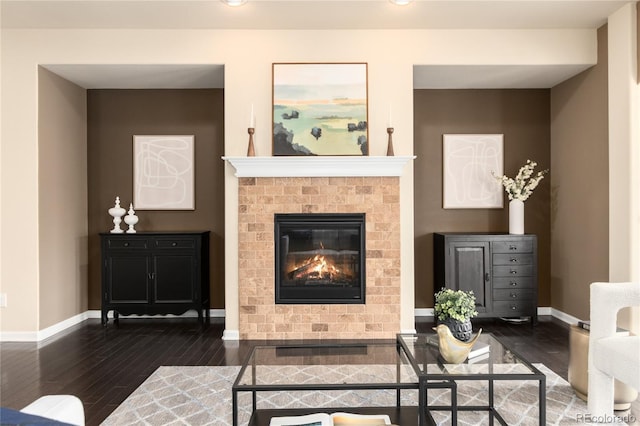 living area featuring dark wood-style floors, a fireplace, and baseboards