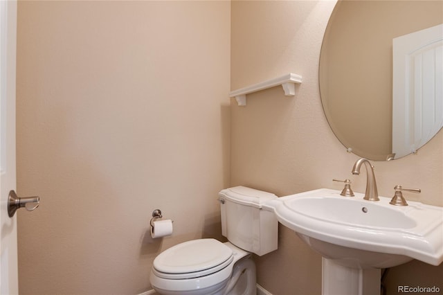 half bathroom featuring toilet and a sink