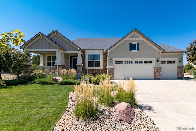 craftsman house with concrete driveway, board and batten siding, stone siding, and a front yard