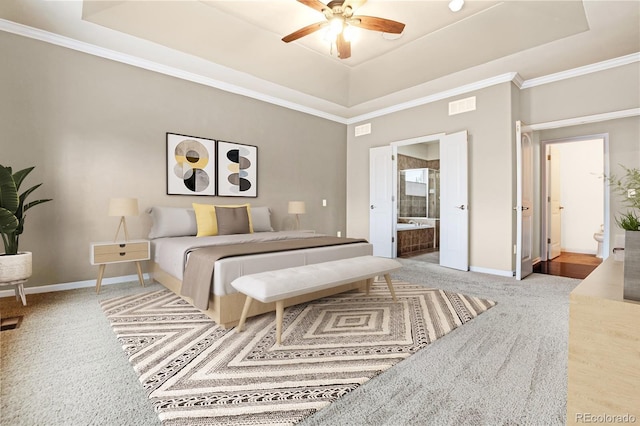 bedroom featuring baseboards, ensuite bathroom, carpet, and a tray ceiling