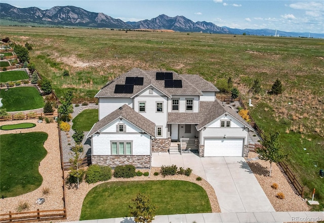 9571 Yucca Ct, Arvada, CO 80007 - view of front of property featuring stone siding, driveway, solar panels, a mountain view, and a garage