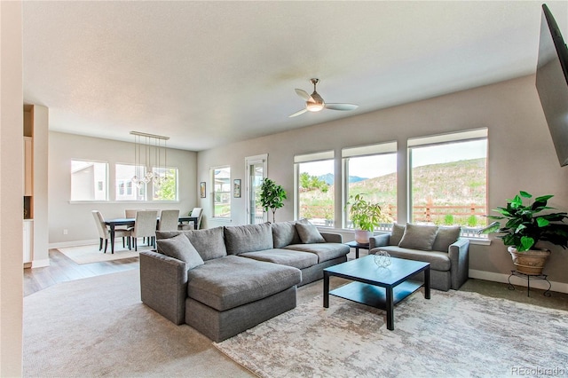 9571 Yucca Ct, Arvada, CO 80007 - living room featuring ceiling fan, baseboards, a chandelier, and wood finished floors