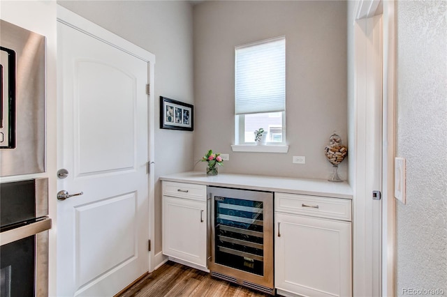 9571 Yucca Ct, Arvada, CO 80007 - bar area with beverage cooler, wood finished floors, and stainless steel oven