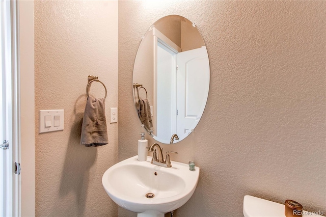 9571 Yucca Ct, Arvada, CO 80007 - half bathroom featuring a sink, toilet, and a textured wall