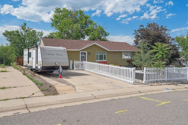 1817 S Perry Way, Denver, CO 80219 - view of front facade with driveway and a fenced front yard