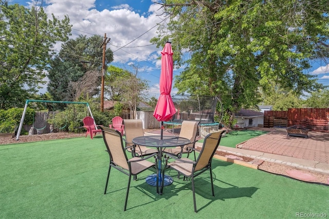 1817 S Perry Way, Denver, CO 80219 - fenced backyard with a trampoline, an outdoor fire pit, and a patio area