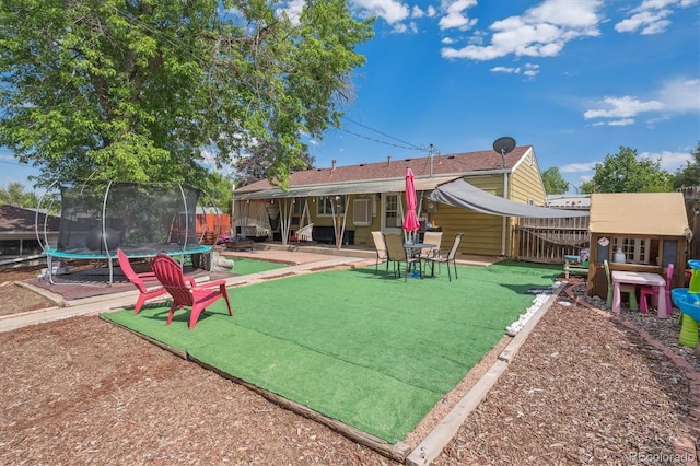 1817 S Perry Way, Denver, CO 80219 - rear view of house with a trampoline, a patio, and a fenced backyard
