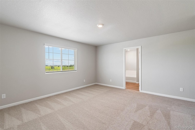 carpeted spare room featuring a textured ceiling