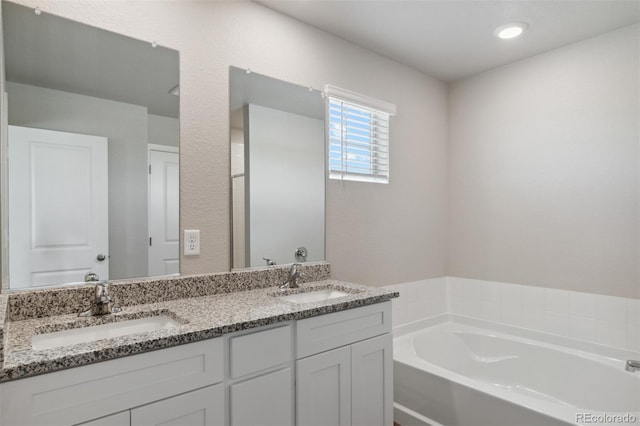 bathroom with a bathing tub and dual bowl vanity