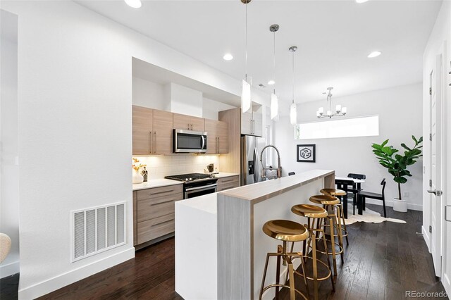 2830 W 32nd Ave, Denver, CO 80211 - kitchen featuring stainless steel appliances, light countertops, a breakfast bar, modern cabinets, and recessed lighting