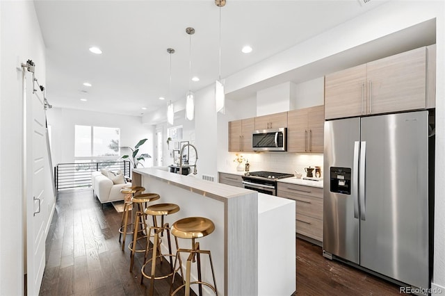 2830 W 32nd Ave, Denver, CO 80211 - kitchen featuring stainless steel appliances, a breakfast bar, light countertops, tasteful backsplash, and dark wood-style floors