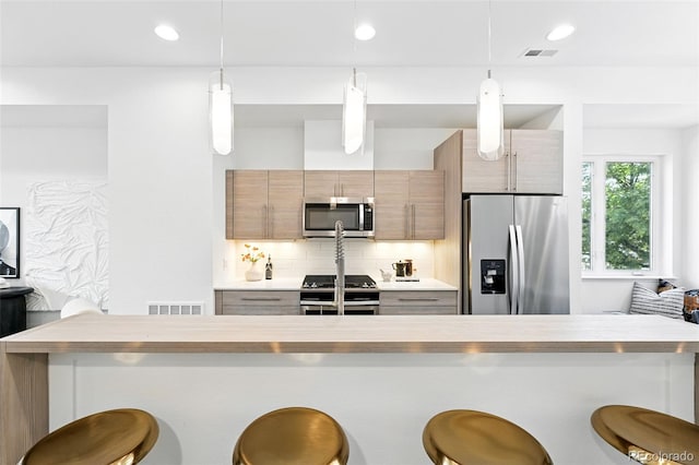 2830 W 32nd Ave, Denver, CO 80211 - kitchen with stainless steel appliances, a breakfast bar area, backsplash, pendant lighting, and recessed lighting