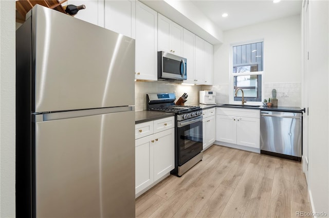 2012 W 46th Ave, Denver, CO 80211 - kitchen with appliances with stainless steel finishes, a sink, dark countertops, recessed lighting, and light wood finished floors