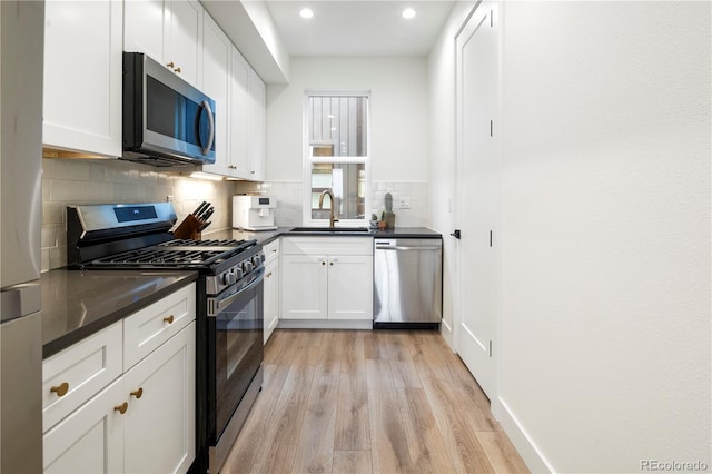 2012 W 46th Ave, Denver, CO 80211 - kitchen featuring appliances with stainless steel finishes, a sink, dark countertops, recessed lighting, and light wood-type flooring