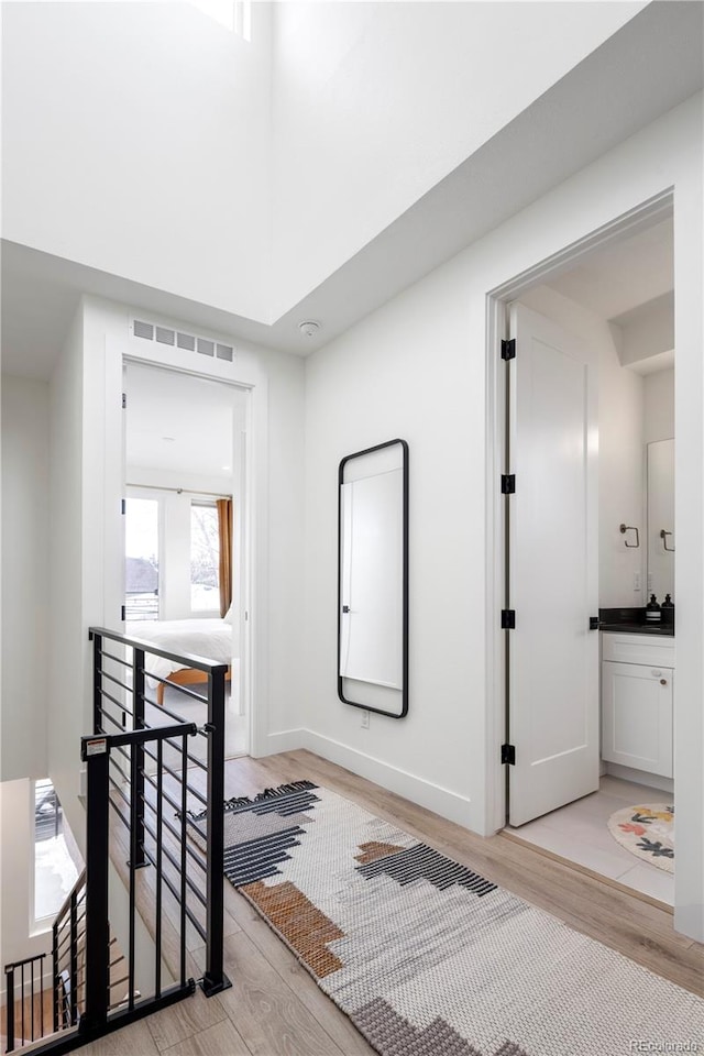 2012 W 46th Ave, Denver, CO 80211 - hall featuring an upstairs landing, light wood-style floors, baseboards, and a high ceiling
