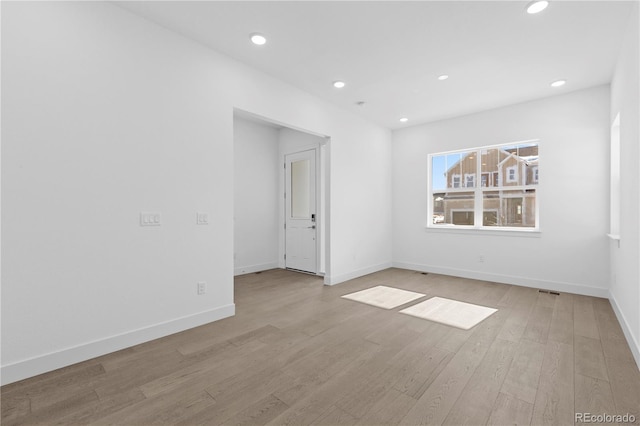 spare room featuring baseboards, recessed lighting, and light wood-style floors