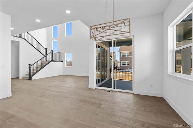 interior space with stairs, wood finished floors, and baseboards